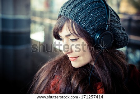 beautiful woman red coat winter listening music headphones park