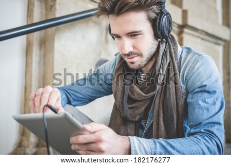 young handsome fashion model using tablet man outdoors