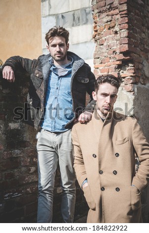 TWO young handsome fashion model men outdoors