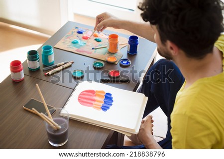 handsome hipster modern man painting at home