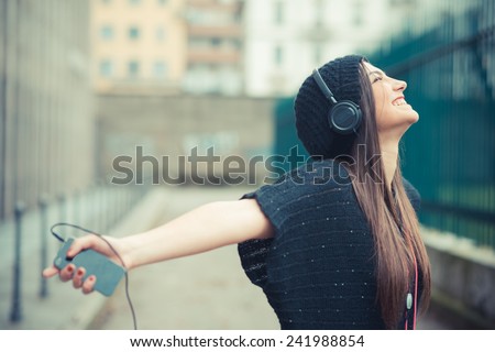 young beautiful brunette woman girl listening music headphones outdoor