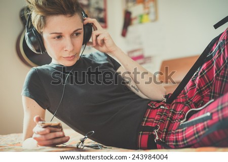 young lesbian stylish hair style woman listening to music at home