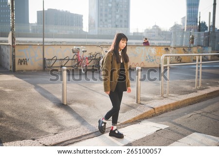 young beautiful asian hipster woman in the city - walking the street crosswalk having fun