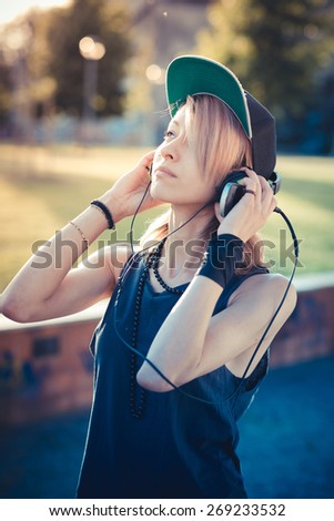 young beautiful model woman listening music in the city