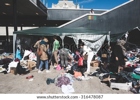 BUDAPEST - SEPTEMBER 7 : War syrian refugees at the Keleti Palyaudvar Railway Station on 1 September 2015 in Budapest, Hungary. Refugees searching clothes in a pile of donated dresses outside station