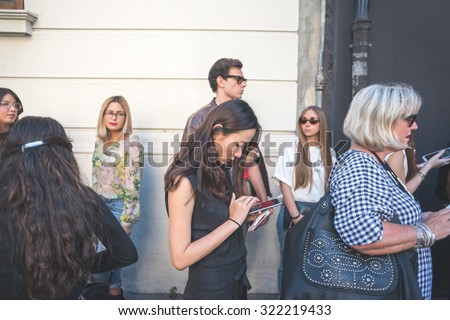 MILAN, ITALY - SEPTEMBER 25: People during Milan Fashion week, Italy on SEPTEMBER 25, 2015. Eccentric and fashionable asiatic woman using smartphone waiting for models and vips at Milan fashion week