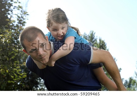 Father and his little daughter play in the backyard.