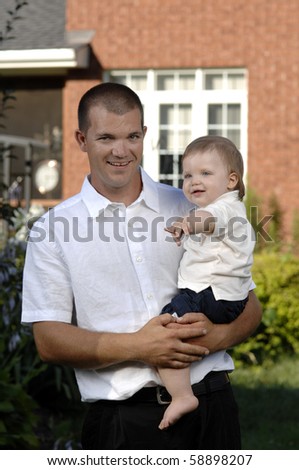 Father and his baby son play in the garden