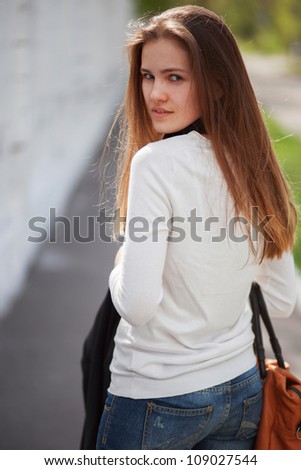 Portrait of looking back young woman outdoors