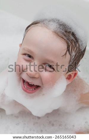 Young boy in the bathroom with beard and cap of soap suds