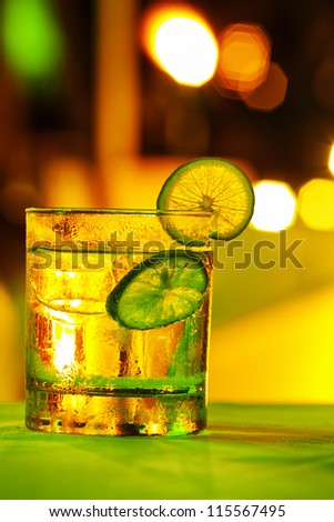 Gin tonic coctail with colorful bokeh. Long exposure shot.