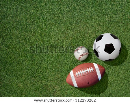 View  of sports equipment including baseball, soccer and football on grass background.