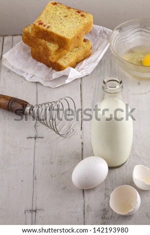 milk egg and sweet bread on white wood, ingredients for baking