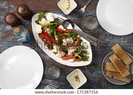Plate with hot spinach salad with cottage cheese and tomatoes. Garnished with garlic and mint