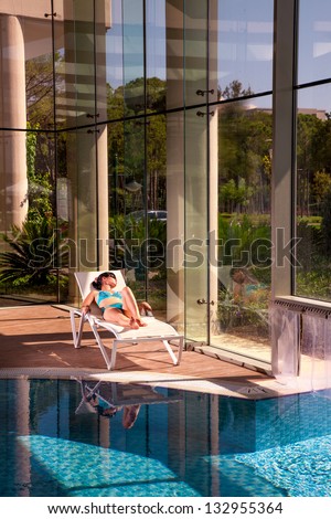 girl on a sun lounger beside the indoor pool