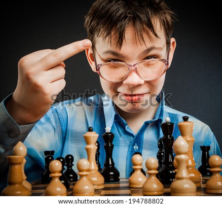 Wunderkind play chess. Funny Nerd boy. Shows the middle finger to the opponent.