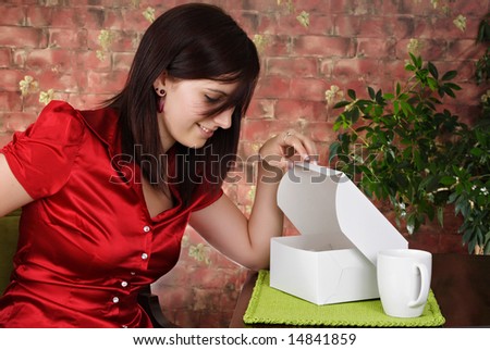 young woman looking in a white pastry box
