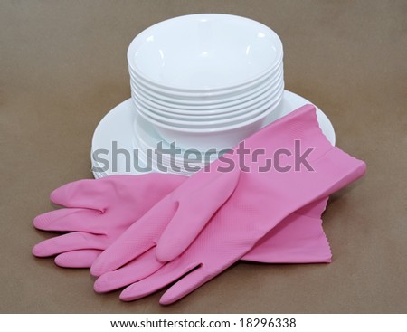 pink gloves and white dishes stacked, brown background
