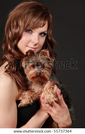 portrait of a beautiful young woman holding a tiny yorkshire terrier dog