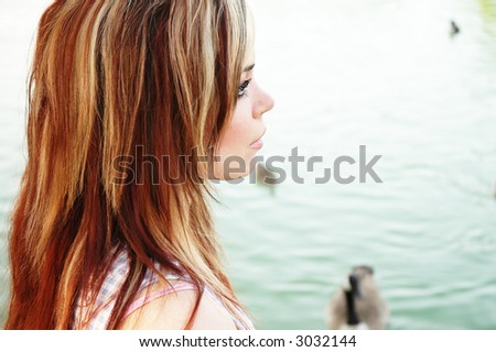 a woman is posing in front of a body of water
