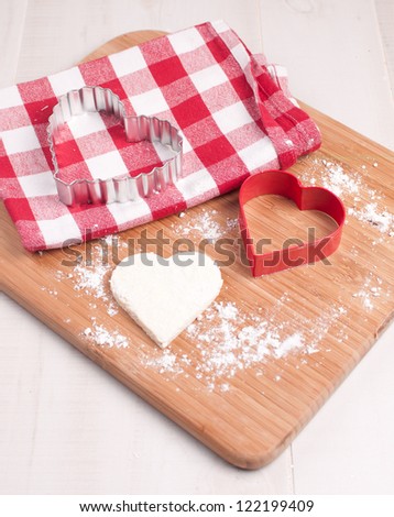 Cutout heart cookie from dough and cookie cutter