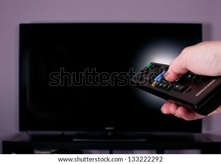 Hand holding remote control for turn off TV
