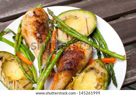 Chicken drumsticks and grilled veggies and avocado