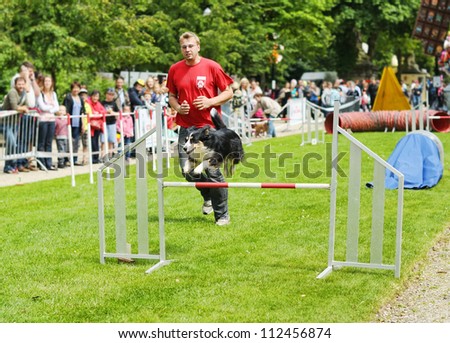 BRUSSELS, BELGIUM - JULY, 21: Unidentified participant of Agility competitions by Club Cynologique d'Ile Sainte-Helene runs with his dog during National Day of Belgium on July 21, 2012 in Brussels.