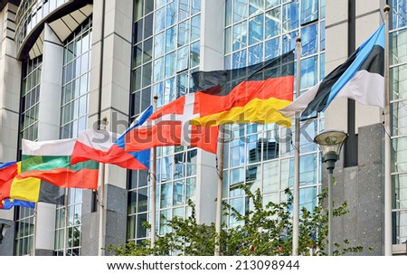 Flags of European Union countries waving near modern European Parliament building in Brussels, Belgium
