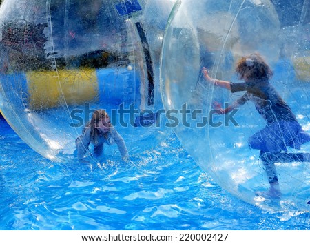 BRUSSELS, BELGIUM-SEPTEMBER 28, 2013: Children play inside of transparent plastic balls in water during fair in Uccle district