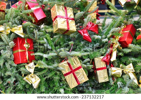 Christmas tree with gift boxes in shiny packages and winter rain drops