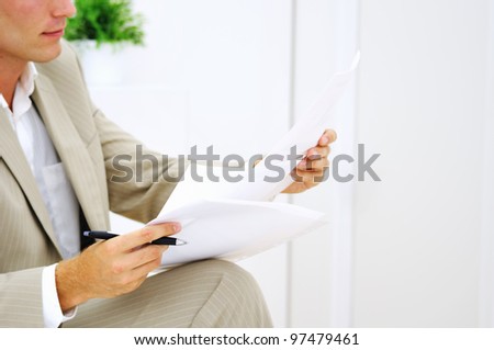 Hands of young man in office preparing to sign papers