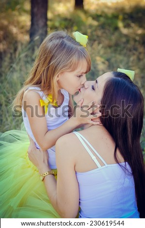 Mother and daughter kissing  in the park