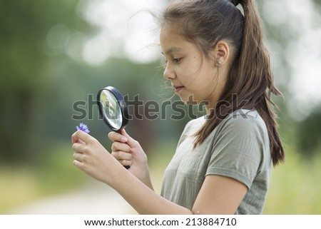 Pretty young girl having outdoor science lesson  exploring nature