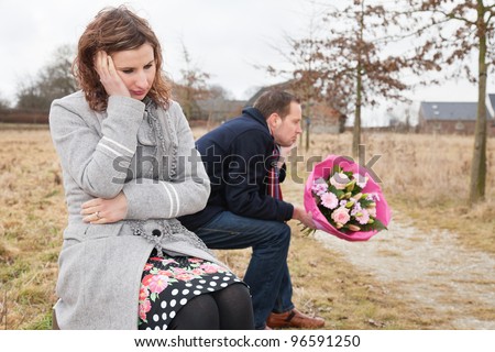 Couple facing communication problems while sitting on bench