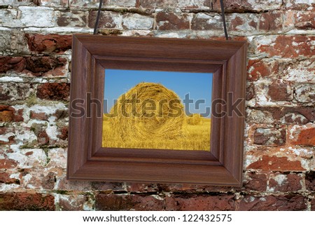 Painting in a wooden frame hanging on an old brick wall