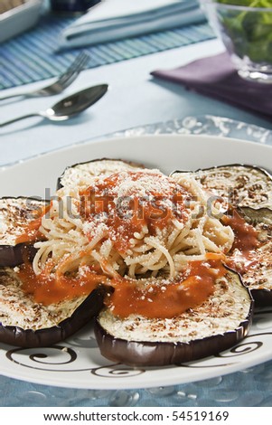 Spaghetti with eggplant and tomato sauce with grated cheese. Studio photography.
