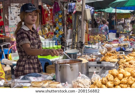 Bangkok, Thailand-April 29th 2014. A girl serves food on a stall in Chinatown. Bangkok is famous for its street food.