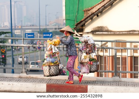 Ho Chi Minh City-Nov 1st: Street vendor on her way back across the river from the market. Vendors can be found all over the city. Image by Kevin Hellon.