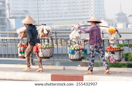 Ho Chi Minh City-Nov 1st: Street vendors crossing the bridge over the river on the way back from the market. Vendors can be found all over the city. Image by Kevin Hellon.