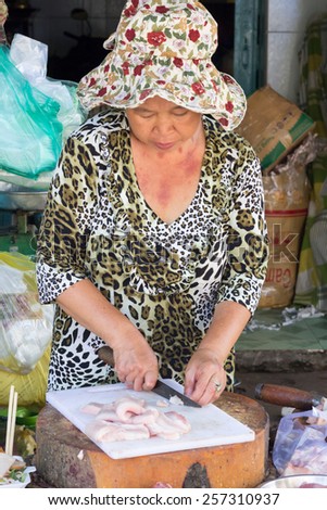 Ho Chi Minh City, Vietnam-Nov 2nd 2013: Woman fishmonger cutting up fish on Cholon market. Cholon is the Chinatown area of the city.