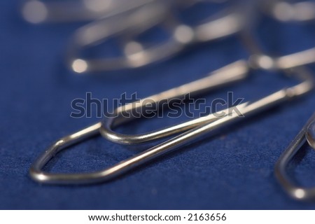 macro picture of metal paper - clip on the blue background