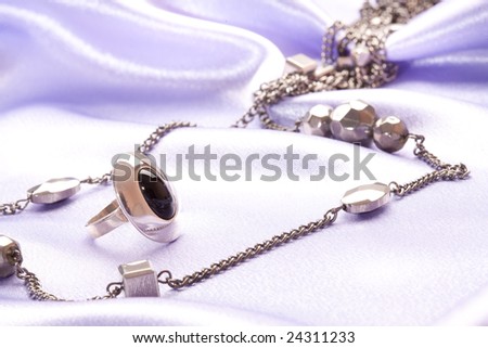 woman`s accessory; macro picture of silver ring and beads