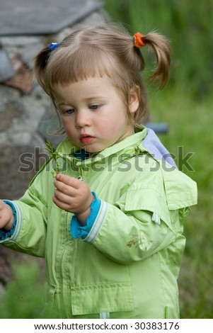 Little girl play on the grass in garden