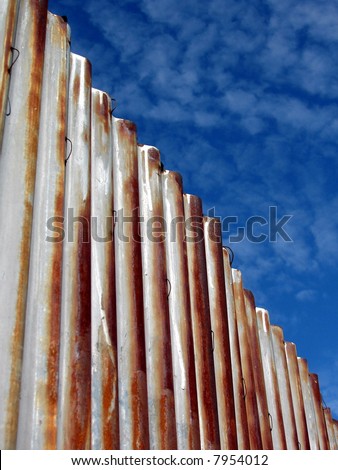 corrugated metal roofing against blue cloudy sky