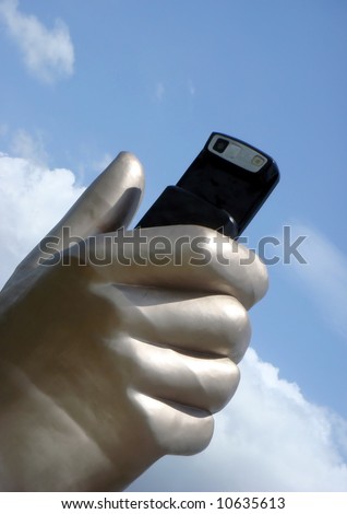 Giant hand sculpture holding a slide cellphone