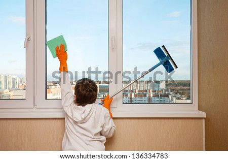 A boy washes a window