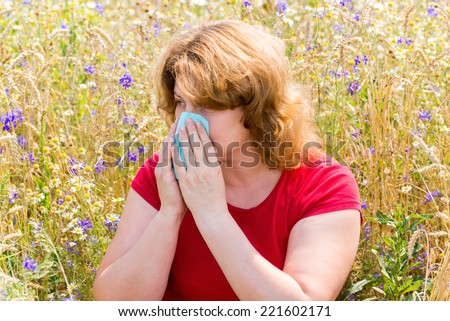 Fat woman with allergic rhinitis in the meadow