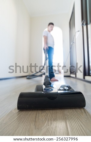 Kid using vacuum cleaner in his house