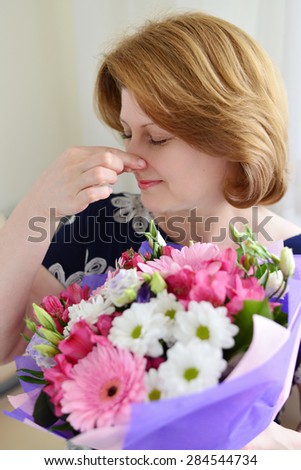 woman with allergic rhinitis is holding a bouquet of flowers